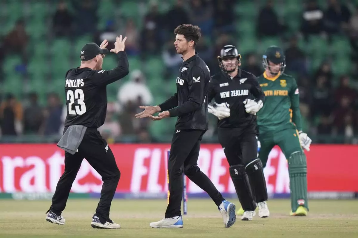 New Zealand's captain Mitchel Santner, second left, celebrates the dismissal of South Africa's Rassie van der Dussen, right, during the ICC Champions Trophy semifinal cricket match between New Zealand and South Africa at Gaddafi Stadium in Lahore, Pakistan, Wednesday, March 5, 2025. (AP Photo/Anjum Naveed)