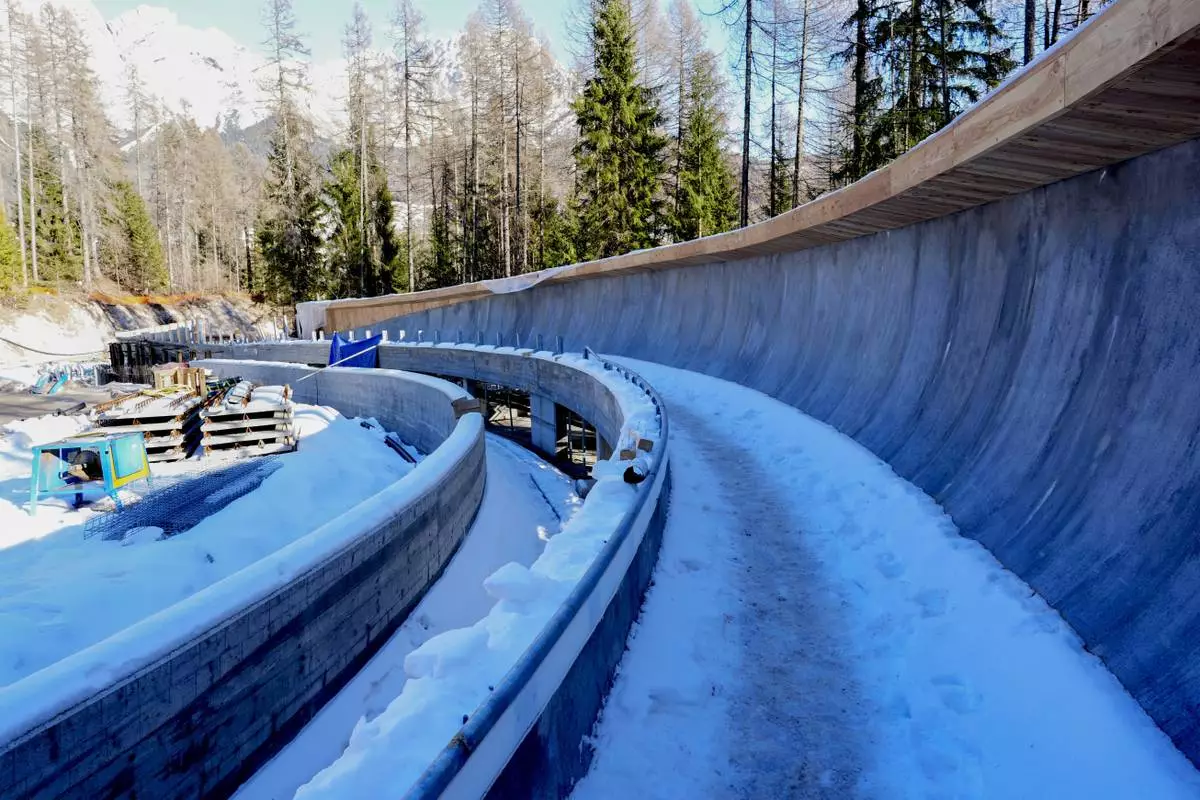 FILE - Construction work takes place at the Cortina Sliding Center, venue for the bob, luge and skeleton disciplines at the Milan Cortina 2026 Winter Olympics, in Cortina d'Ampezzo, Italy, Thursday, Jan. 16, 2025. (AP Photo/Giovanni Auletta, file)