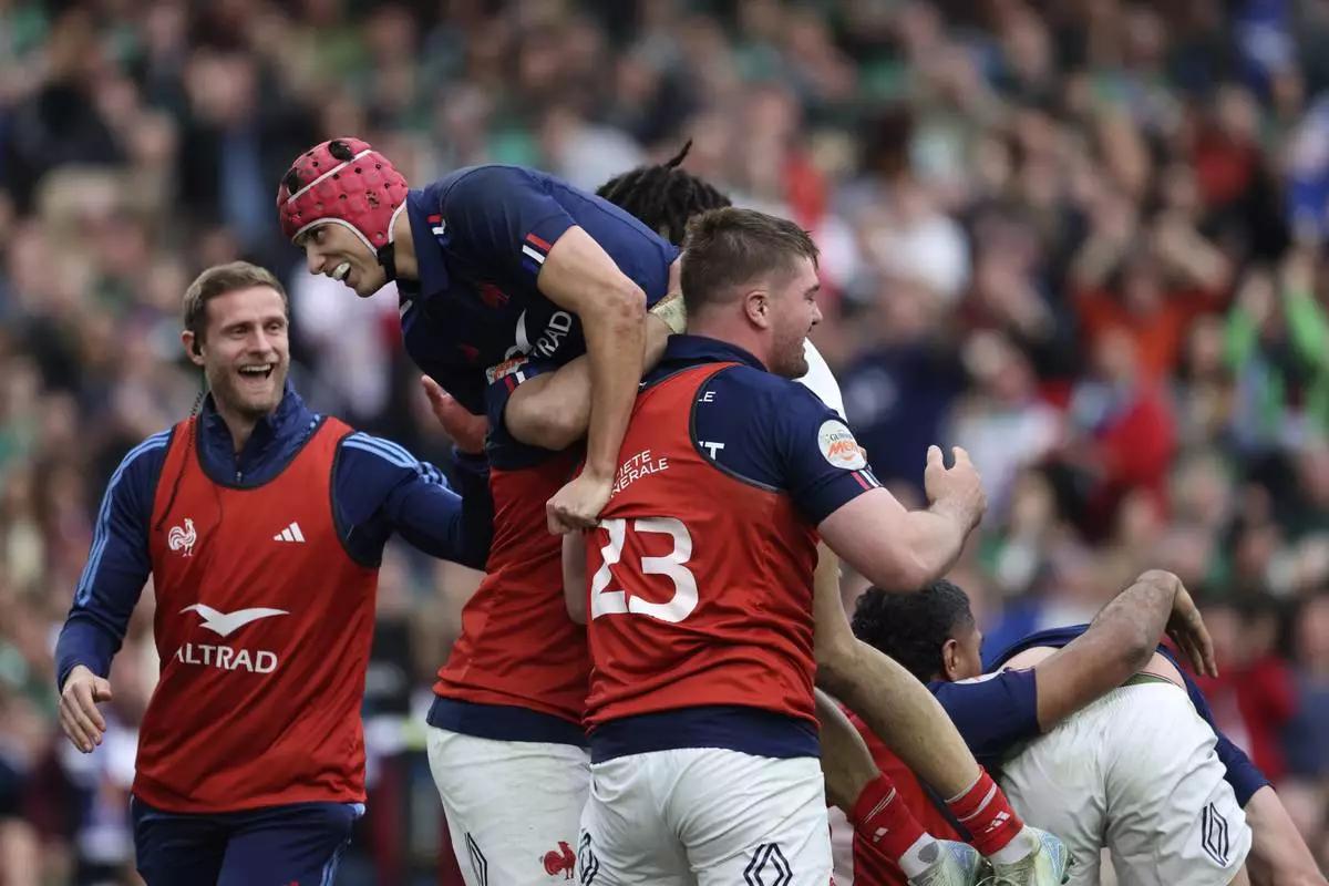 France's Louis Bielle-Biarrey, top, celebrates after his teammate Damian Penaud scored a try during the Six Nations rugby union match between Ireland and France, at Aviva Stadium, Dublin, Ireland, Saturday, March 8, 2025. (AP Photo/Peter Morrison)