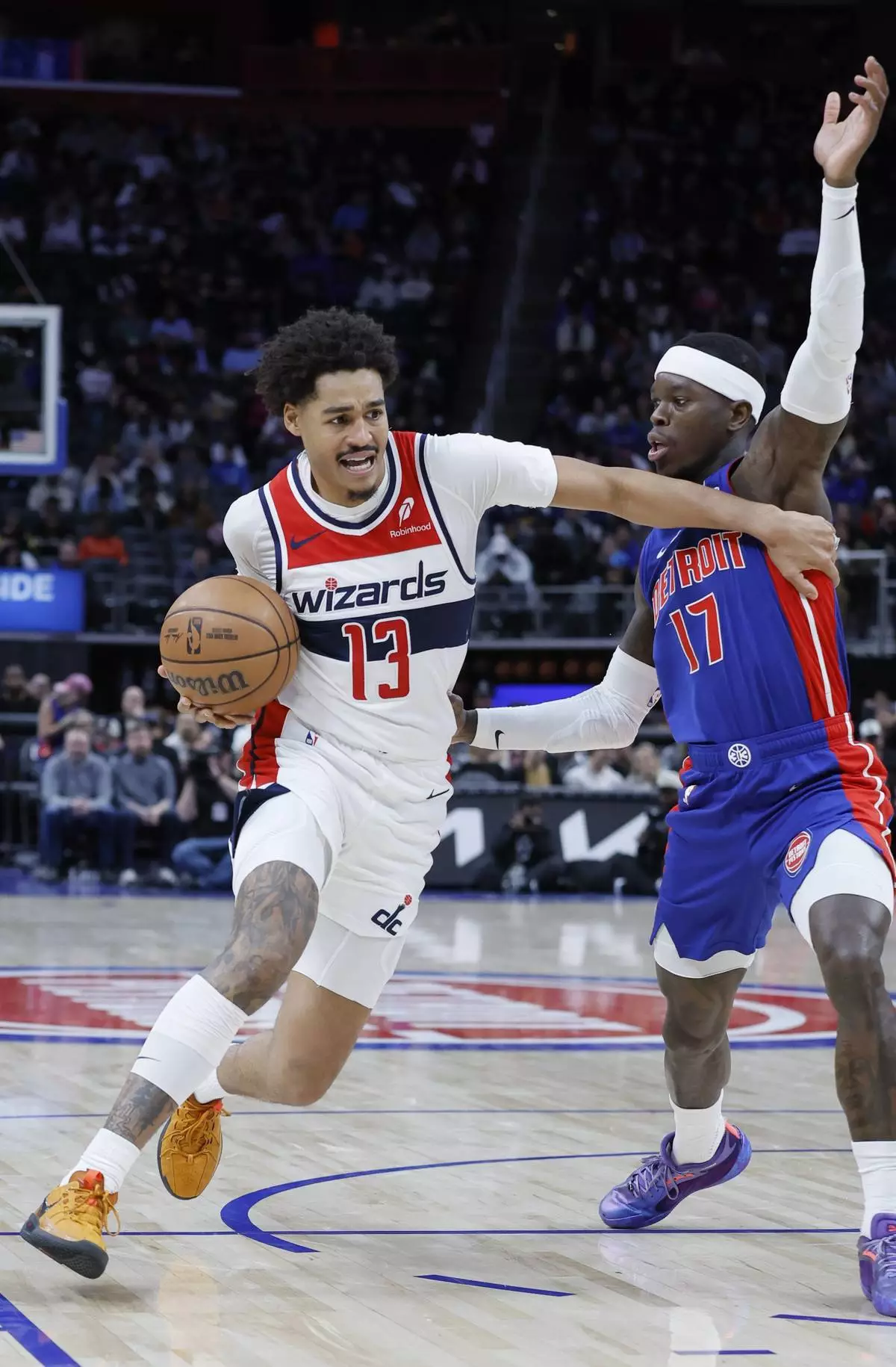 Washington Wizards guard Jordan Poole (13) drives to the basket against Detroit Pistons guard Dennis Schroder (17) during the first half of an NBA basketball game Tuesday, March 11, 2025, in Detroit. (AP Photo/Duane Burleson)