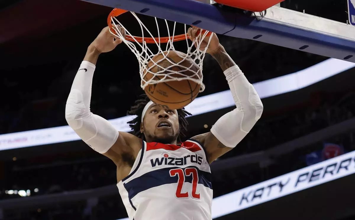 Washington Wizards forward Richaun Holmes (22) dunks the ball against the Detroit Pistons during the first half of an NBA basketball game Tuesday, March 11, 2025, in Detroit. (AP Photo/Duane Burleson)