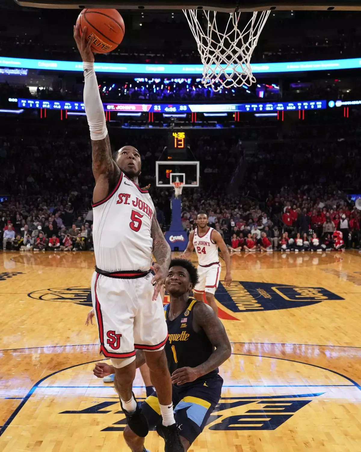 St. John's's Deivon Smith (5) drives past Marquette's Kam Jones (1) during the first half of an NCAA college basketball game in the semifinals of the Big East tournament Friday, March 14, 2025, in New York. (AP Photo/Frank Franklin II)