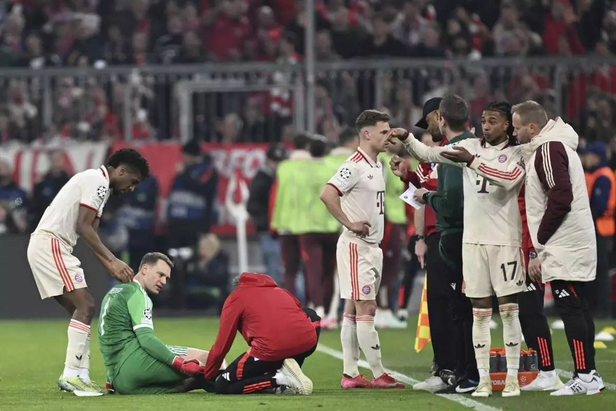 Munich's goalkeeper Manuel Neuer, second left, receives treatment during the Champions League round of 16 first leg soccer match between FC Bayern Munich and Bayer 04 Leverkusen in Munich, Germany, Wednesday, March 5, 2025. (Sven Hoppe/dpa via AP)