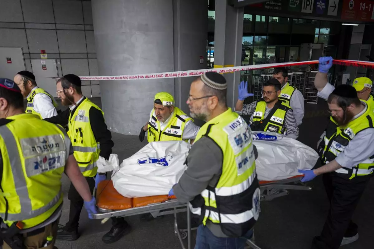 Members of ZAKA rescue services carry the body of a 70-year-old killed in stabbing attack in Haifa, Israel, on Monday, March 30, 2025. Four others were also injured in the incident. (AP Photo/Ariel Schalit)