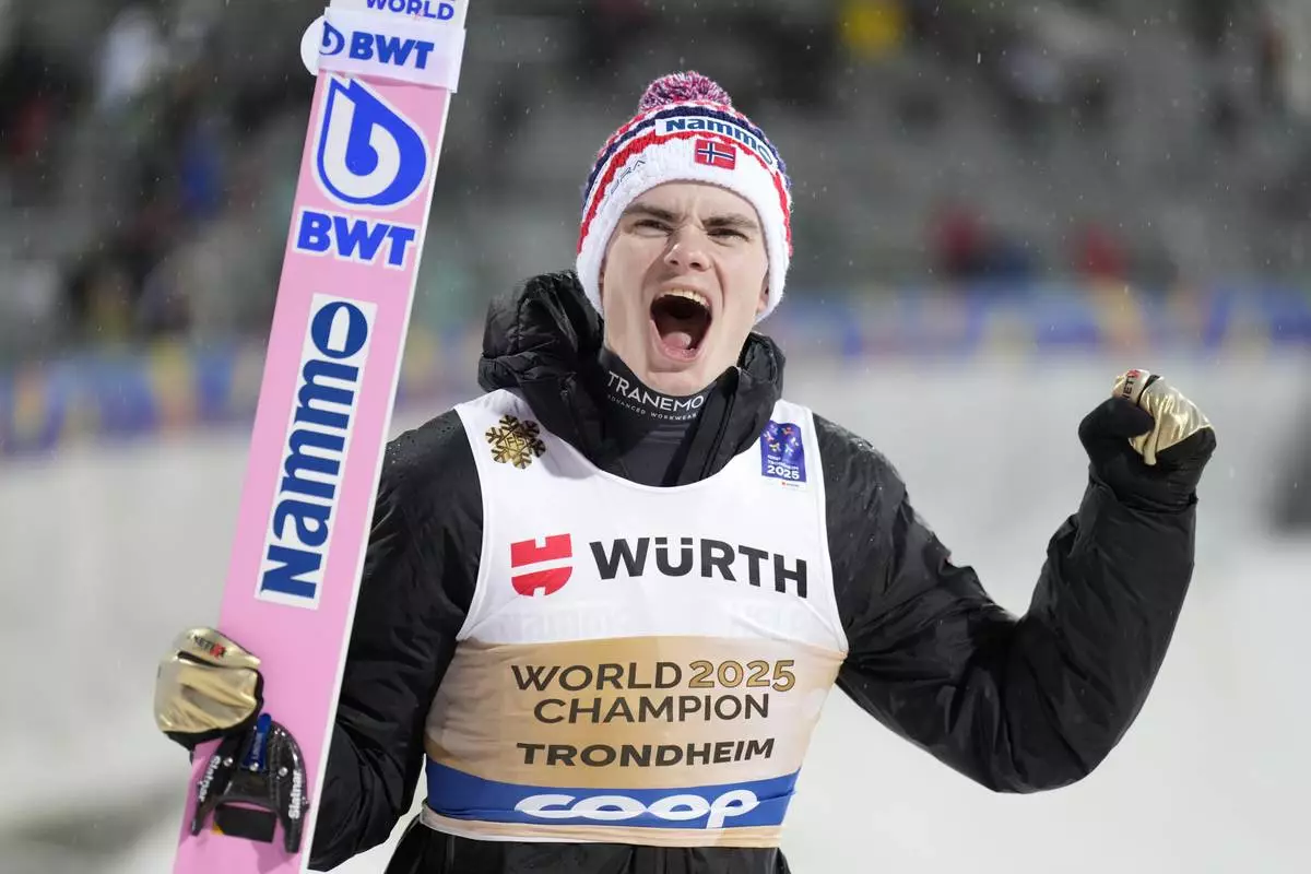 Marius Lindvik, of Norway, celebrates after winning the gold medal in the ski jumping men's normal hill HS102 event at the Nordic World Ski Championships in Trondheim, Norway, Sunday, March 2, 2025. (AP Photo/Matthias Schrader)
