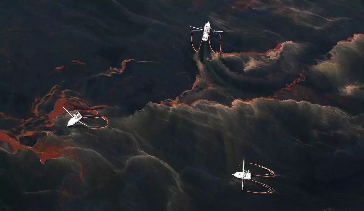 FILE - Shrimp boats are used to collect oil with booms in the waters of Chandeleur Sound, La., May 5, 2010. (AP Photo/Eric Gay, File)