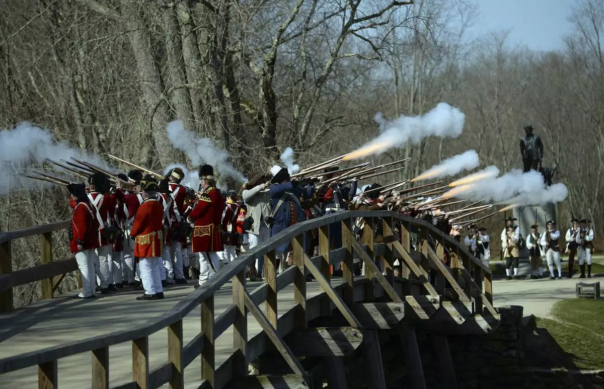 FILE - Acton Minutemen and British soldiers fire a ceremonial volley from the North Bridge, after the re-enactment of the North Bridge fight marking the 241st anniversary of the start of the American Revolutionary War, Monday, April 18, 2016, in Concord, Mass. (John Walker/The Metro West Daily News via AP,File)