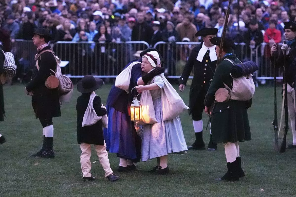 Colonials embrace while gathering prior to facing the British Regulars during a reenactment celebration of the 250th anniversary of the Battle of Lexington and start of the American Revolution, Saturday, April 19, 2025, in Lexington, Mass. (AP Photo/Charles Krupa)