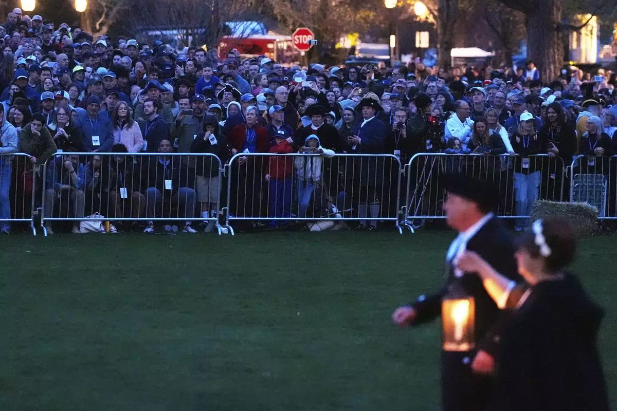 Thousands watch before sunrise during a reenactment celebration of the 250th anniversary of the Battle of Lexington and start of the American Revolution, Saturday, April 19, 2025, in Lexington, Mass. (AP Photo/Charles Krupa)
