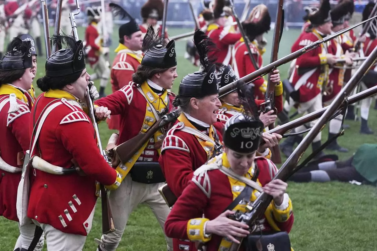 British Regulars fire on New England colonial militia, also known as a Minuteman, during a reenactment celebration of the 250th anniversary of the Battle of Lexington and start of the American Revolution, Saturday, April 19, 2025, in Lexington, Mass. (AP Photo/Charles Krupa)