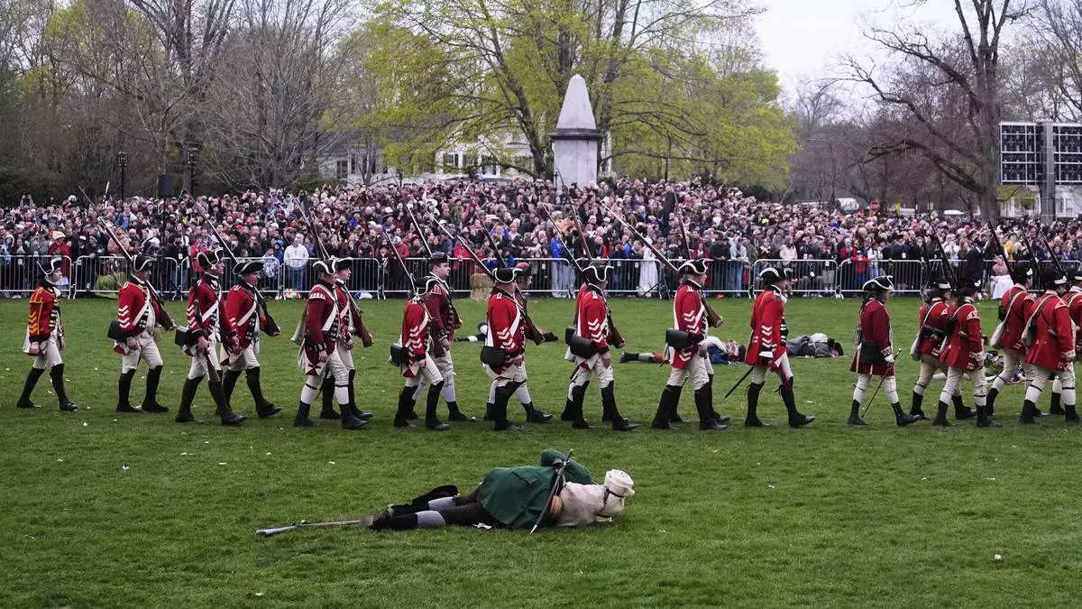 British Regulars march past a fallen New England colonial militia, also known as a Minuteman, during a reenactment celebration of the 250th anniversary of the Battle of Lexington and start of the American Revolution, Saturday, April 19, 2025, in Lexington, Mass. (AP Photo/Charles Krupa)