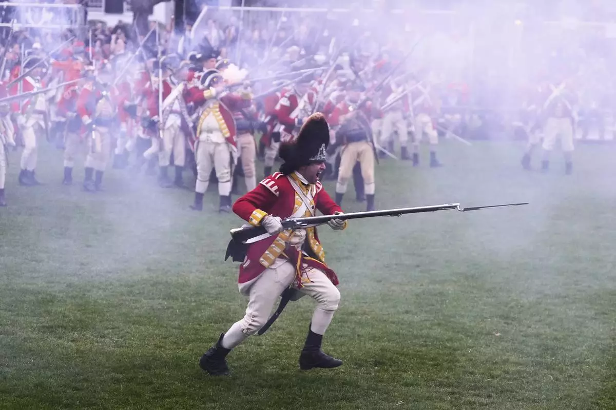 British Regulars advance on New England colonial militia, also known as a Minutemen, during a reenactment celebration of the 250th anniversary of the Battle of Lexington and start of the American Revolution, Saturday, April 19, 2025, in Lexington, Mass. (AP Photo/Charles Krupa)