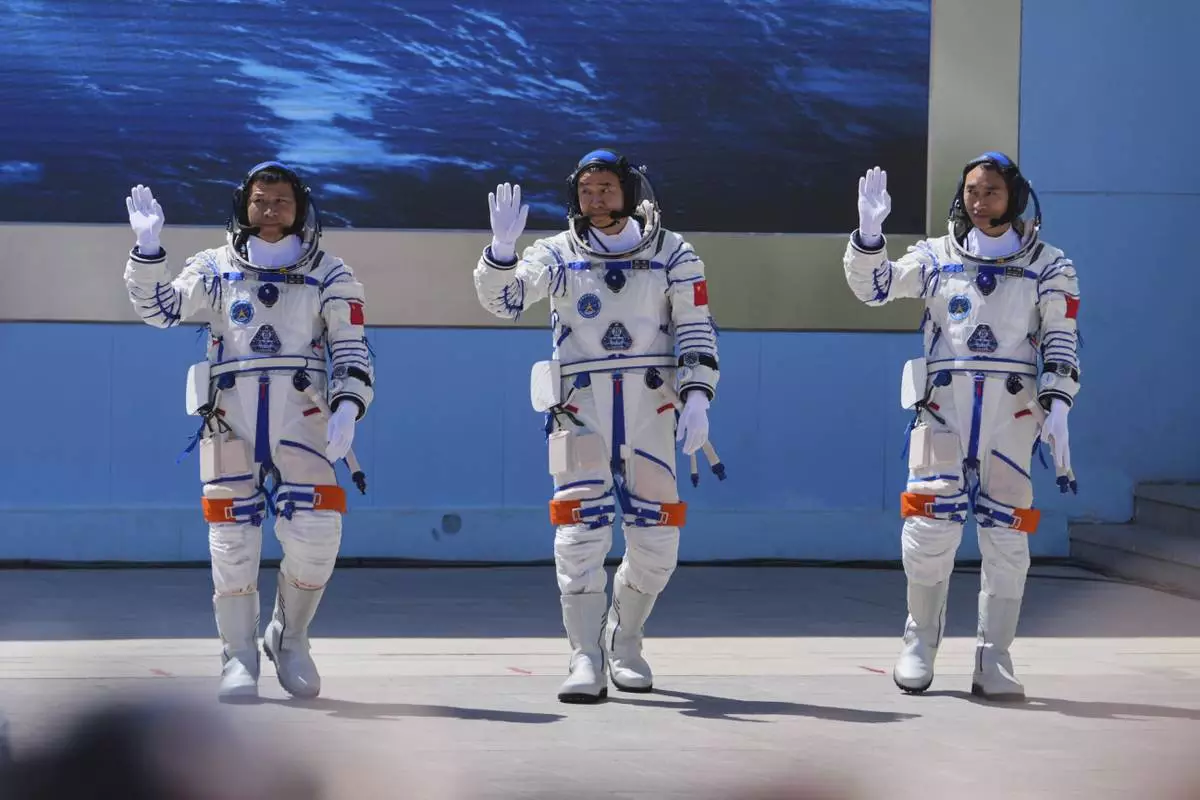 Chinese astronauts for the Shenzhou 20 mission, from right, Chen Zhongrui, Chen Dong and Wang Jie wave as they attend a send-off ceremony for their manned space mission at the Jiuquan Satellite Launch Center in northwestern China, Thursday, April 24, 2025. (AP Photo/Andy Wong)
