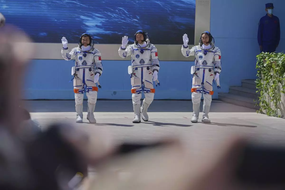 Chinese astronauts for the Shenzhou 20 mission, from right, Chen Zhongrui, Chen Dong and Wang Jie wave as they attend a send-off ceremony for their manned space mission at the Jiuquan Satellite Launch Center in northwestern China, Thursday, April 24, 2025. (AP Photo/Andy Wong)