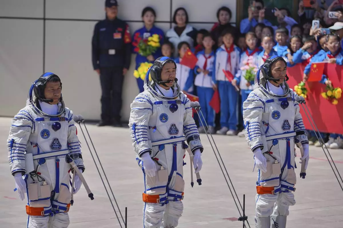 Chinese astronaut for the Shenzhou 20 mission, Chen Dong, center, speaks next to his comrades Chen Zhongrui, right, and Wang Jie as they attend a send-off ceremony for their manned space mission at the Jiuquan Satellite Launch Center in northwestern China, Thursday, April 24, 2025. (AP Photo/Andy Wong)