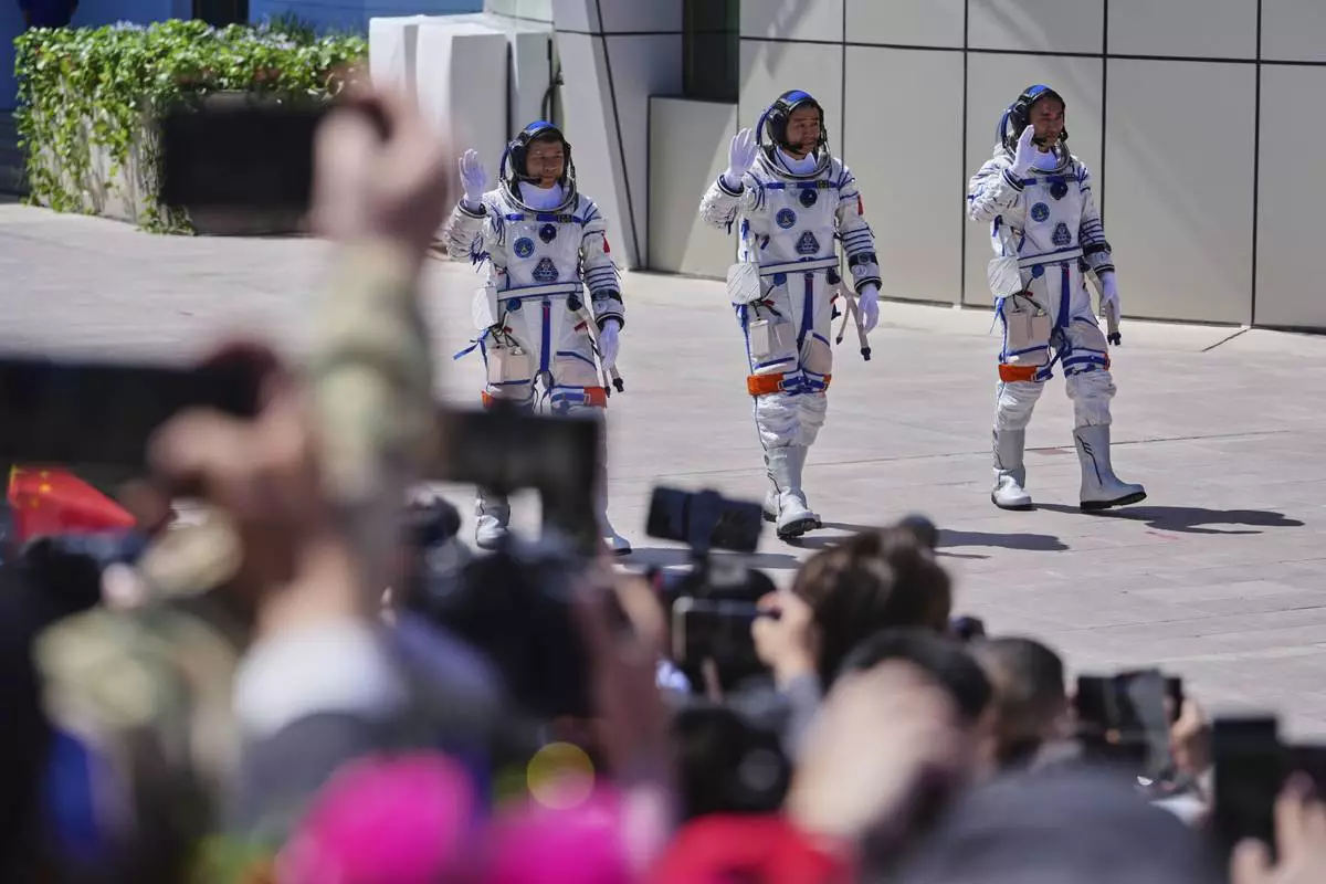 Chinese astronauts for the Shenzhou 20 mission, from right, Chen Zhongrui, Chen Dong and Wang Jie wave as they attend a send-off ceremony for their manned space mission at the Jiuquan Satellite Launch Center in northwestern China, Thursday, April 24, 2025. (AP Photo/Andy Wong)