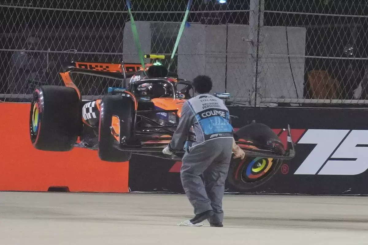 McLaren driver Lando Norris' car is carried out of the track after crashing during the qualifying session ahead of the Formula One Saudi Arabian Grand Prix at the Jeddah Corniche Circuit in Jeddah, Saudi Arabia, Saturday, April 19, 2025. (AP Photo/Altaf Qadri)