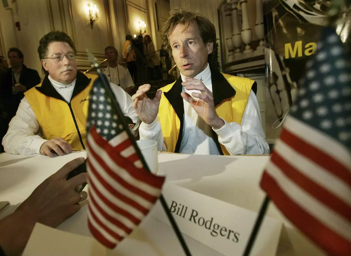FILE - Four-time Boston Marathon winner, Bill Rodgers, speaks, as Boston Marathon wheelchair winner and pioneer, Bob Hall, listens at left, during a news conference in Boston, April 15, 2005. (AP Photo/Elise Amendola, File)