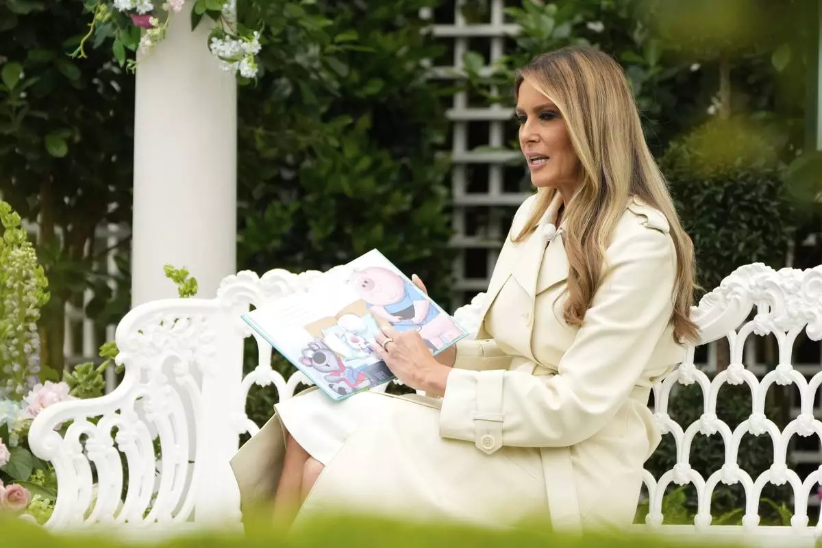 First lady Melania Trump reads a book to children during the White House Easter Egg Roll at the White House, Monday, April 21, 2025, in Washington. (AP Photo/Mark Schiefelbein)