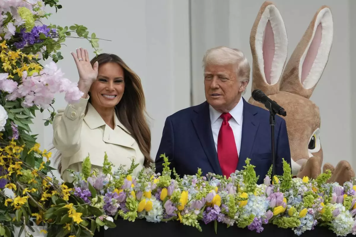 President Donald Trump watches as first lady Melania Trump waves from the Blue Room Balcony during the White House Easter Egg Roll on the South Lawn of the White House, Monday, April 21, 2025, in Washington. (AP Photo/Alex Brandon)