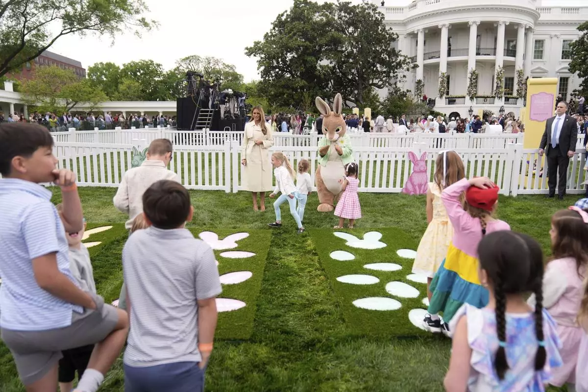 First lady Melania Trump talks with children as they play a game of hopscotch during the White House Easter Egg Roll on the South Lawn of the White House, Monday, April 21, 2025, in Washington. (AP Photo/Mark Schiefelbein)