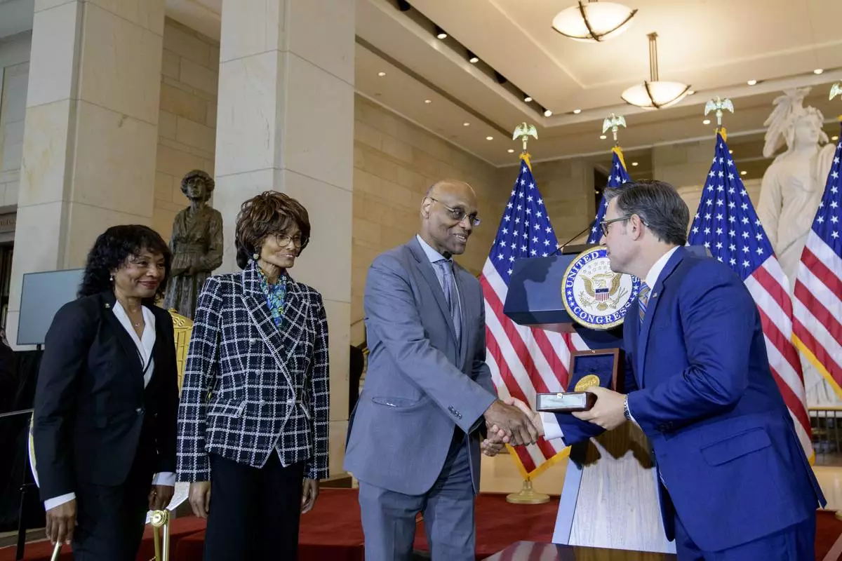 House Speaker Mike Johnson, R-La., right, presents the Congressional Gold Medal to Stanley Earley III, son of Lt. Col. Charity Adams Earley, second from right, as Judith Earley, second from left, and retired Amy Col. Edna W. Cummings, left, watch during a ceremony honoring the Six Triple Eight, on Capitol Hill, Tuesday, April 29, 2025, in Washington. (AP Photo/Rod Lamkey, Jr.)