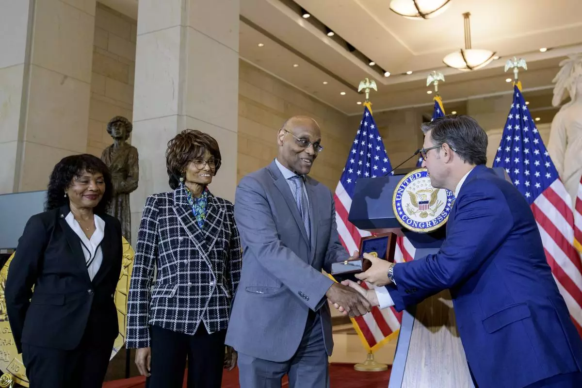 House Speaker Mike Johnson, R-La., right, presents the Congressional Gold Medal to Stanley Earley III, son of Lt. Col. Charity Adams Earley, second from right, as Judith Earley, second from left, and retired Amy Col. Edna W. Cummings, left, watch during a ceremony honoring the Six Triple Eight, on Capitol Hill, Tuesday, April 29, 2025, in Washington. (AP Photo/Rod Lamkey, Jr.)