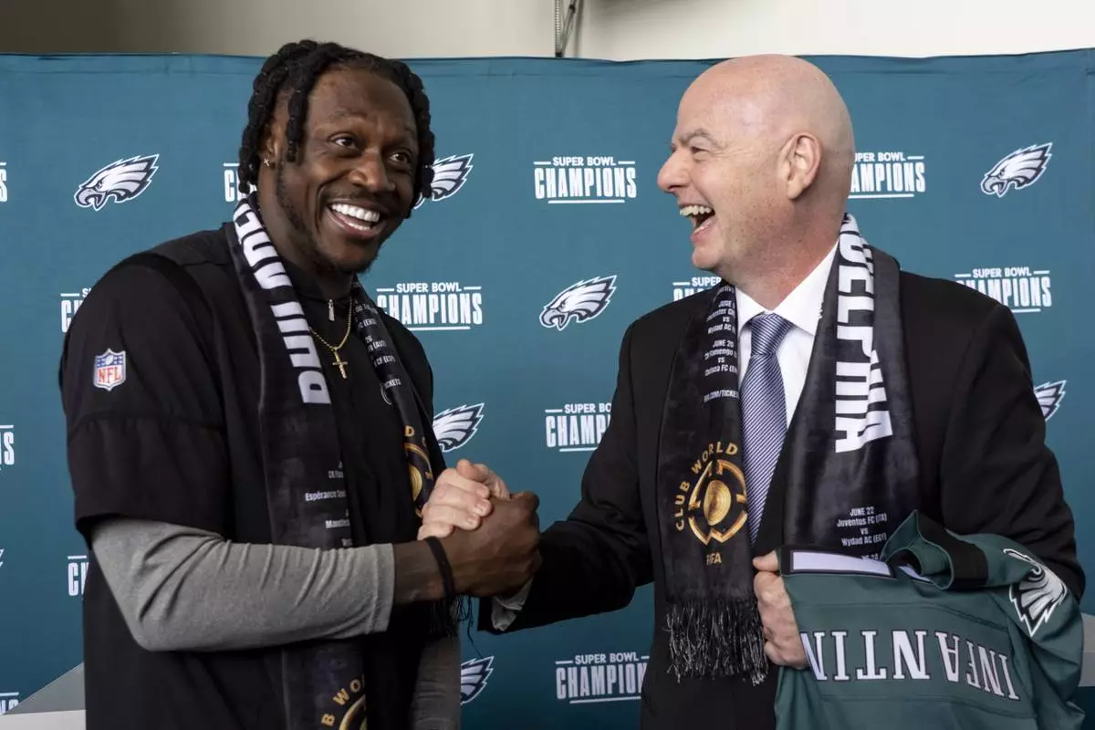 FIFA President Gianni Infantino, right, talks with Philadelphia Eagles NFL football player A.J. Brown, left, at a welcoming event for the 2025 FIFA Club World Cup soccer tournament, Thursday, April 10, 2025, in Philadelphia. (AP Photo/Chris Szagola)