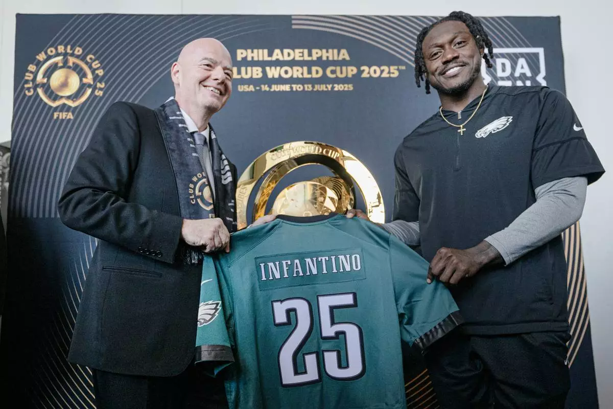 FIFA President Gianni Infantino, left, and Philadelphia Eagles NFL football player A.J. Brown, left, pose with an Eagles jersey during a welcoming event for the 2025 FIFA Club World Cup soccer tournament, Thursday, April 10, 2025, in Philadelphia. (Jose F. Moreno/The Philadelphia Inquirer via AP)