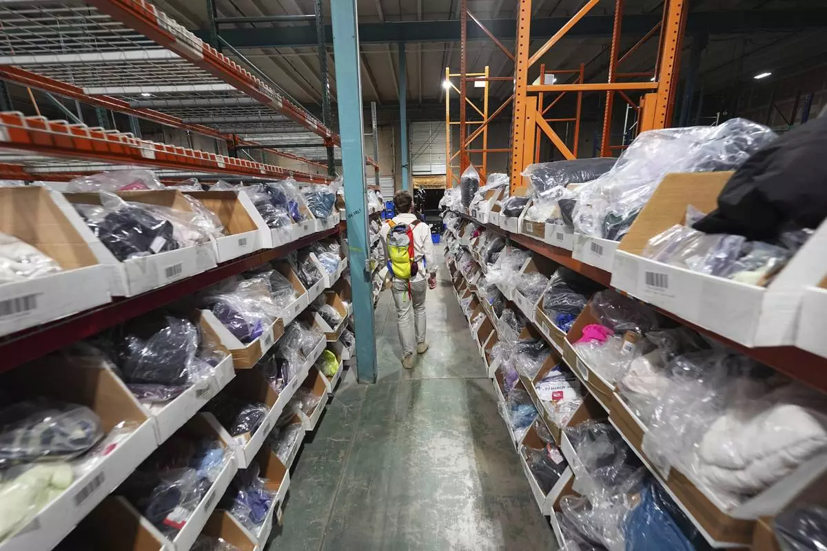 Bags of returned or overstocked clothing, shoes, boots, coats, packs and other items sit in a fulfillment warehouse after the goods were cleaned or repaired to be marketed on resale platforms in Englewood, Colo., on Thursday, April 17, 2025. (AP Photo/David Zalubowski)