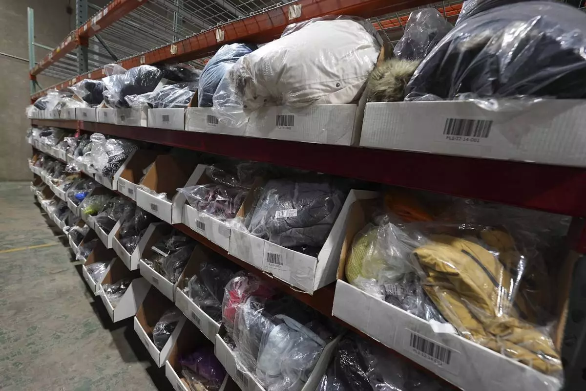 Bags of returned or overstocked clothing, shoes, boots, coats, packs and other items sit in a fulfillment warehouse after the goods were cleaned or repaired as they are marketed on resale platforms Thursday, April 17, 2025, in Englewood, Colo. (AP Photo/David Zalubowski)