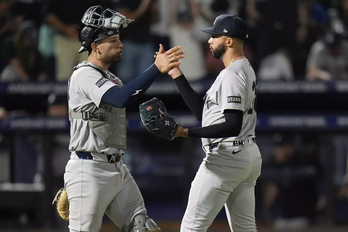 New York Yankees pitcher Devin Williams, right, celebrates with catcher J.C. Escarra after closing out the Tampa Bay Rays during the ninth inning of a baseball game Thursday, April 17, 2025, in Tampa, Fla. (AP Photo/Chris O'Meara)