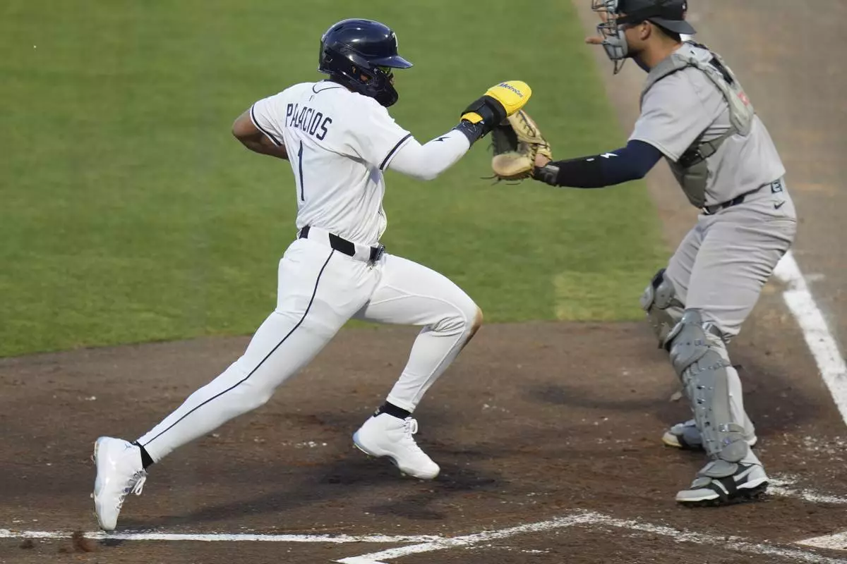 Tampa Bay Rays' Richie Palacios scores in front of New York Yankees catcher J.C. Escarra on a sacrifice fly by Taylor Walls during the second inning of a baseball game Thursday, April 17, 2025, in Tampa, Fla. (AP Photo/Chris O'Meara)