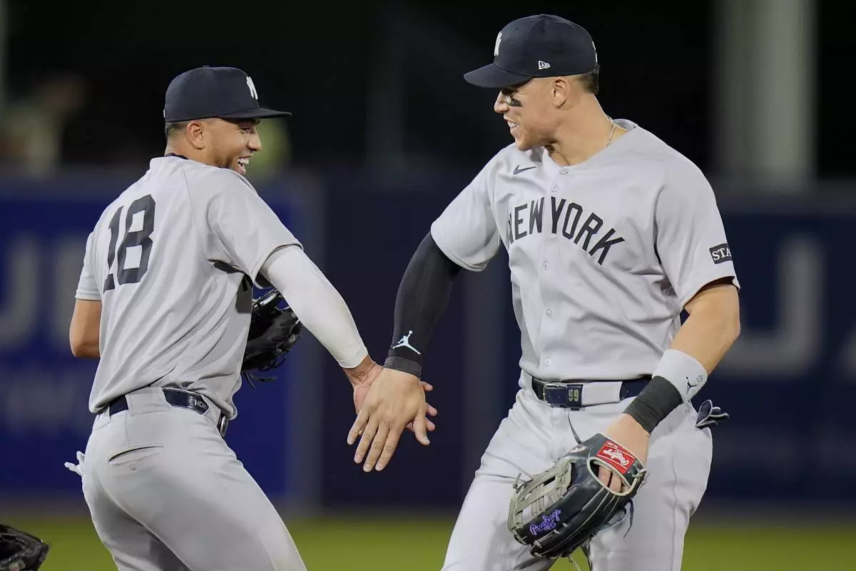 New York Yankees infielder Oswald Peraza (18) and outfielder Aaron Judge celebrate after the team defeated the Tampa Bay Rays during a baseball game Thursday, April 17, 2025, in Tampa, Fla. (AP Photo/Chris O'Meara)