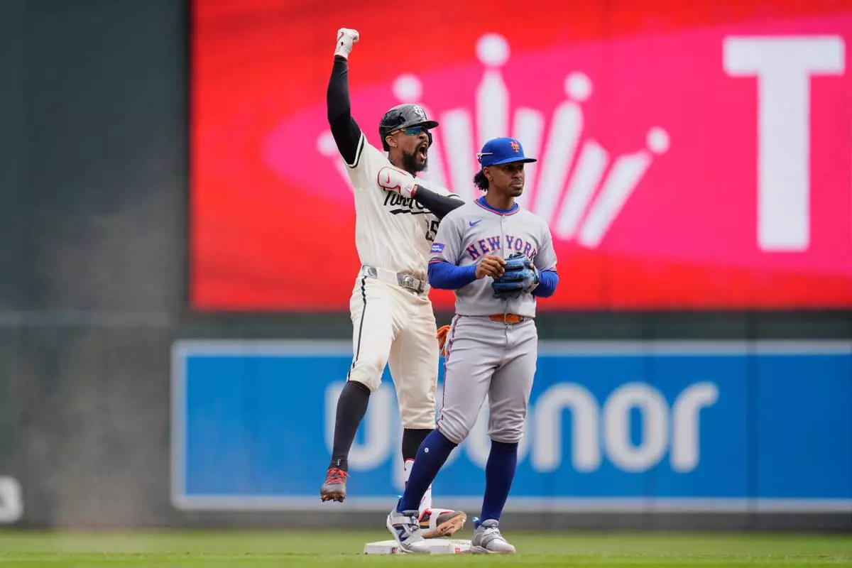 Minnesota Twins' Byron Buxton (25), left, celebrates next to New York Mets shortstop Francisco Lindor (12) after hitting an RBI-single during the fifth inning of a baseball game, Wednesday, April 16, 2025, in Minneapolis. (AP Photo/Abbie Parr)