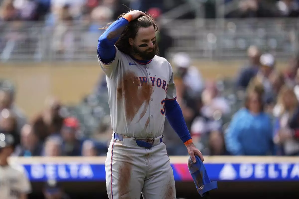 New York Mets' Jesse Winker (3) walks back to the dugout after being thrown out at home plate during the second inning of a baseball game against the Minnesota Twins, Wednesday, April 16, 2025, in Minneapolis. (AP Photo/Abbie Parr)