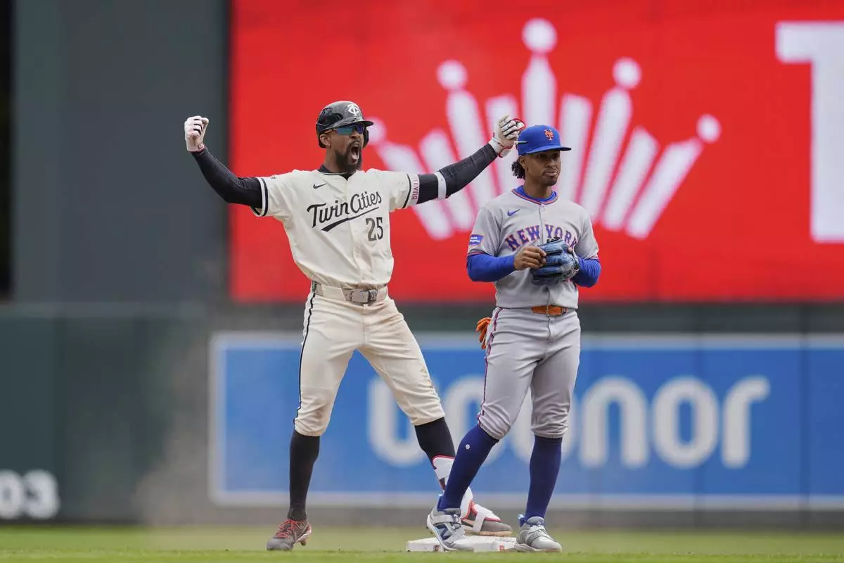 Minnesota Twins' Byron Buxton (25), left, celebrates next to New York Mets shortstop Francisco Lindor (12) after hitting an RBI-single during the fifth inning of a baseball game, Wednesday, April 16, 2025, in Minneapolis. (AP Photo/Abbie Parr)