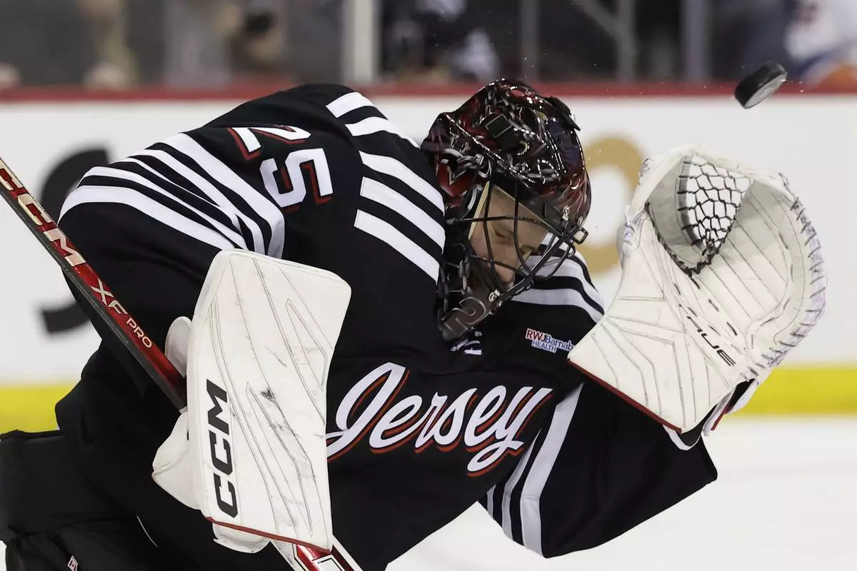 New Jersey Devils goaltender Jacob Markstrom makes a save in the third period of an NHL hockey game against the New York Islanders Sunday, April 13, 2025, in Newark, N.J. (AP Photo/Adam Hunger)