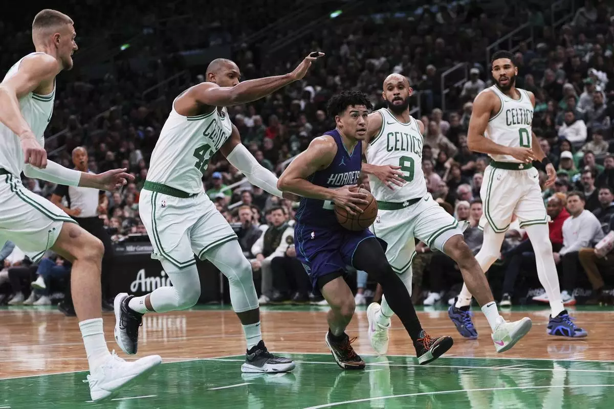 Charlotte Hornets guard KJ Simpson, center, drives to the basket against the Boston Celtics during the first half of an NBA basketball game, Friday, April 11, 2025, in Boston. (AP Photo/Charles Krupa)