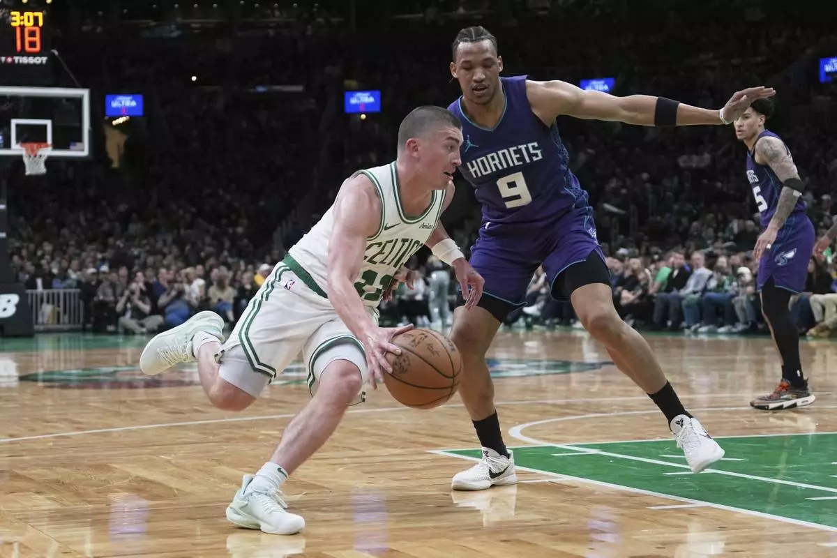 Boston Celtics guard Payton Pritchard, left, drives to the basket against Charlotte Hornets guard Wendell Moore Jr. (9) during the second half of an NBA basketball game, Friday, April 11, 2025, in Boston. (AP Photo/Charles Krupa)