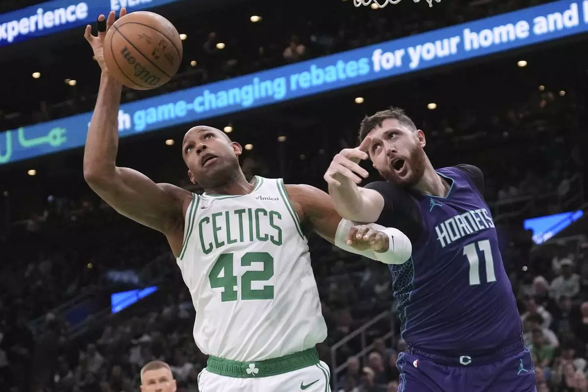Boston Celtics center Al Horford (42) battles for a rebound against Charlotte Hornets center Jusuf Nurkic (11) during the first half of an NBA basketball game, Friday, April 11, 2025, in Boston. (AP Photo/Charles Krupa)
