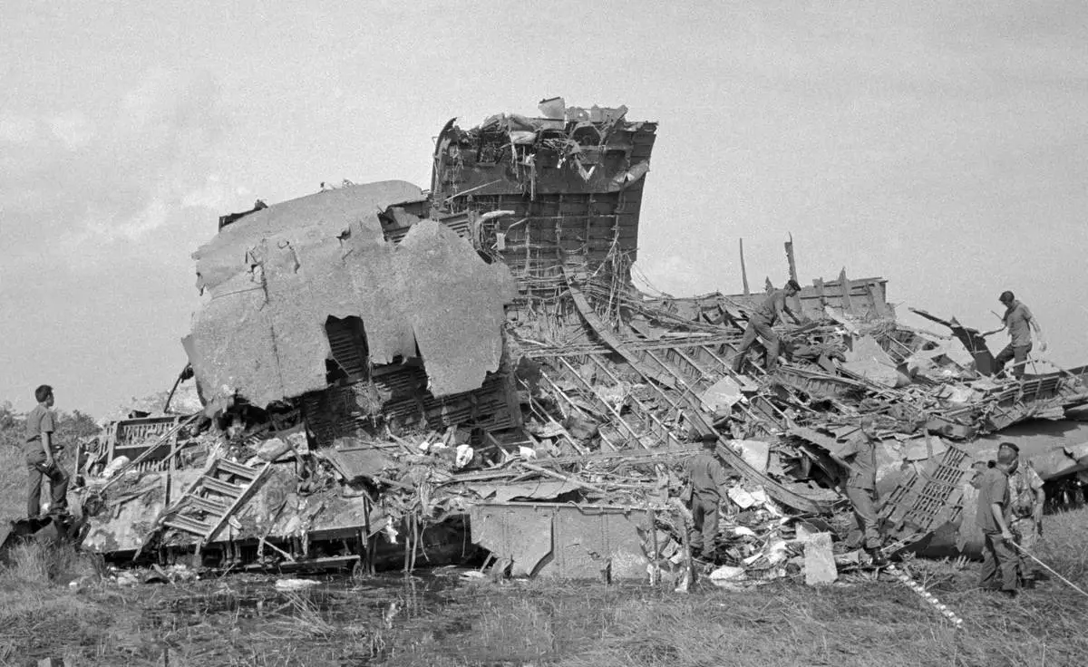FILE- Rescue and recovery workers search the wreckage of a C-5A Galaxy transport plane on April 5, 1975, one day after the plane carrying Vietnamese orphans crashed shortly after takeoff from Saigon's Tan Son Nhut Airport during the initial flight of Operation Babylift. Seventy-eight children and about 50 adults died in the crash; about 170 people survived. Subsequent flights of Operation Babylift evacuated more than 2,500 children to the United States and other countries for adoption. (AP Photo/Dang Van Phuoc, File)
