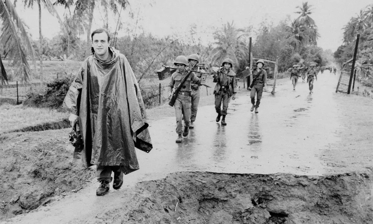 Associated Press correspondent Peter Arnett, left, marches in column with Vietnamese troops as he covers the war in Vietnam, Nov. 11, 1965. The conflict is described as one of the most difficult and dangerous for those who cover it because of the way it is fought. There are no front lines or clearly marked friendly or enemy territories. (AP Photo)