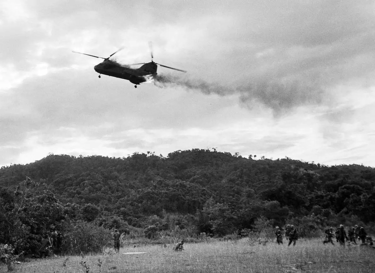 FILE- A U.S. Marine CH-46 Sea Knight helicopter comes down in flames after being hit by enemy ground fire during Operation Hastings, just south of the Demilitarized Zone between North and South Vietnam, July 15, 1966. The helicopter crashed and exploded on a hill, killing one crewman and 12 Marines. Three crewman escaped with serious burns. (AP Photo/Horst Faas. File)