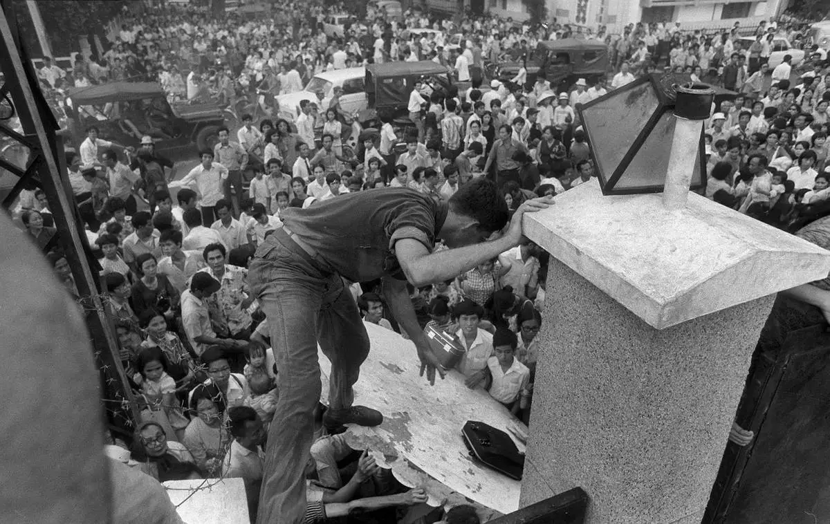 FILE - In this April 29, 1975, file photo, South Vietnamese civilians try to scale the 14-foot wall of the U.S. embassy in Saigon, trying to reach evacuation helicopters as the last Americans departed from Vietnam. (AP Photo/File)