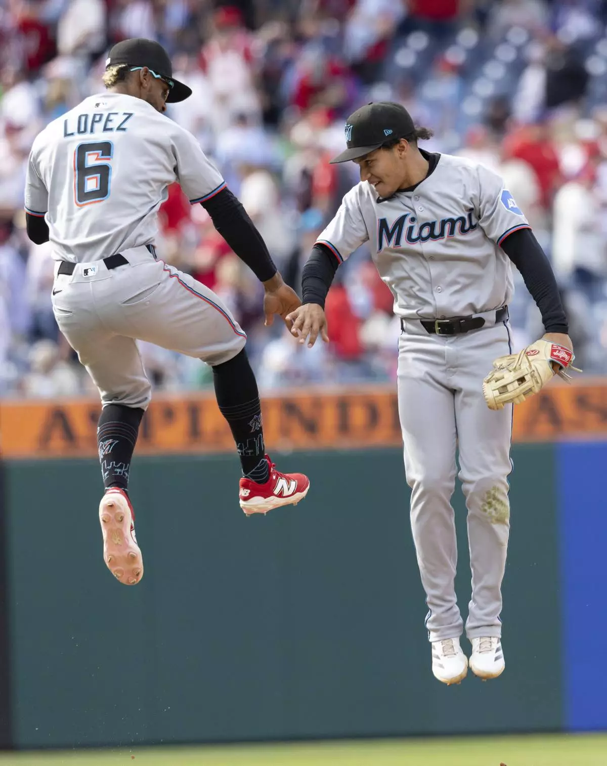 Miami Marlins second baseman Otto Lopez (6) and left fielder Javier Sanoja celebrate their win against the Philadelphia Phillies in a baseball game, Sunday, April 20, 2025, in Philadelphia. (AP Photo/Laurence Kesterson)