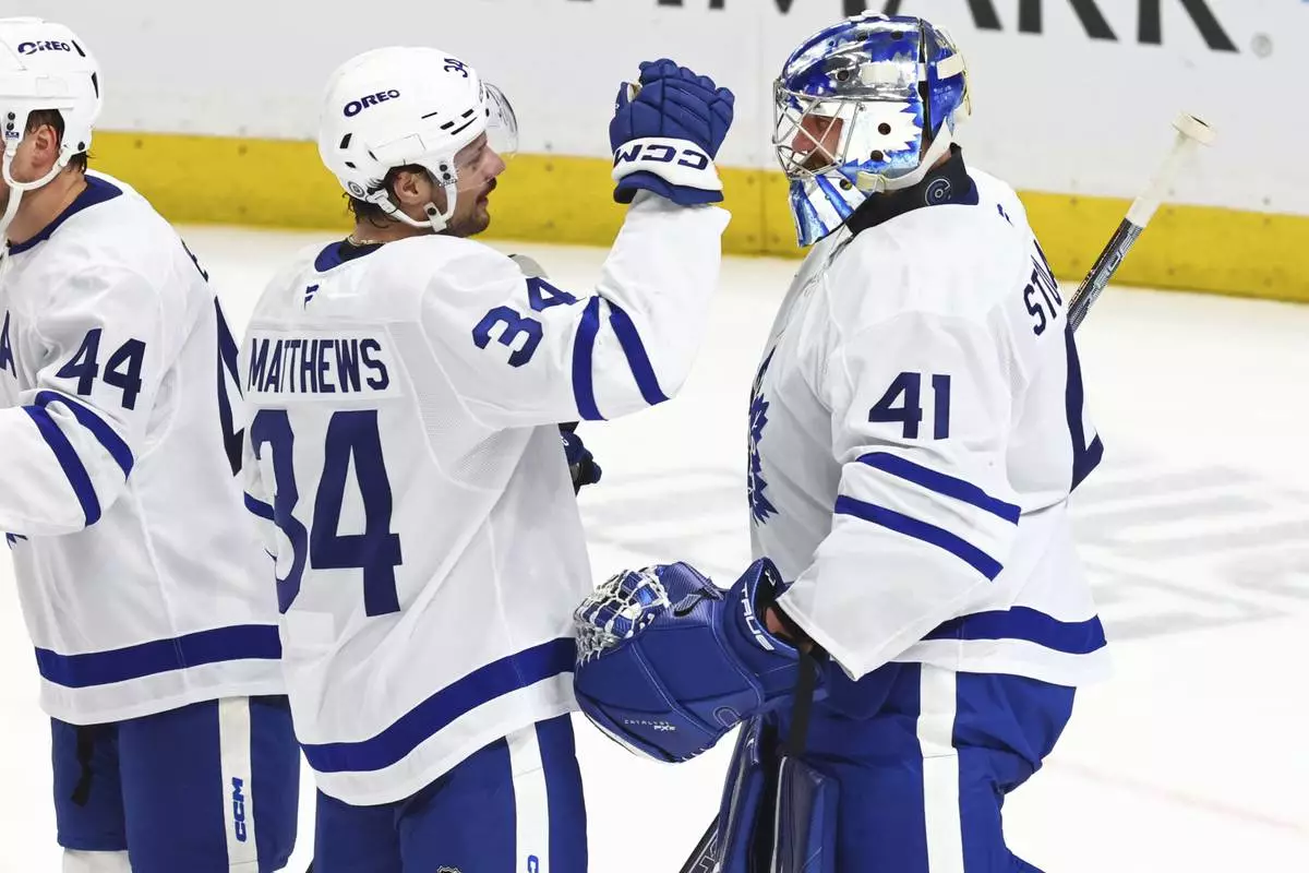 Toronto Maple Leafs center Auston Matthews (34) and goaltender Anthony Stolarz (41) celebrate a their team's victory following the third period of an NHL hockey game against the Buffalo Sabres, Tuesday, April 15, 2025, in Buffalo, N.Y. (AP Photo/Jeffrey T. Barnes)