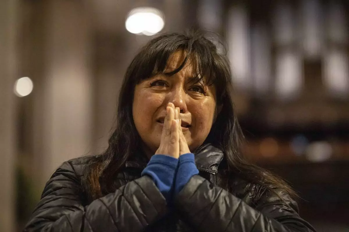 A parishioner weeps in front of a picture of Pope Francis at St. Patrick's Cathedral, Monday, April 21, 2025, in New York. (AP Photo/Yuki Iwamura)
