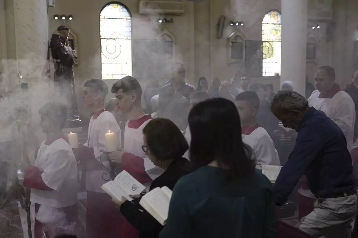 Christian Palestinians attend a special prayer for the late Pope Francis after the news of his death at age 88, at the Holy Family Church in the Old City of Gaza, Gaza City, Monday, April 21, 2025. (AP Photo/Jehad Alshrafi)