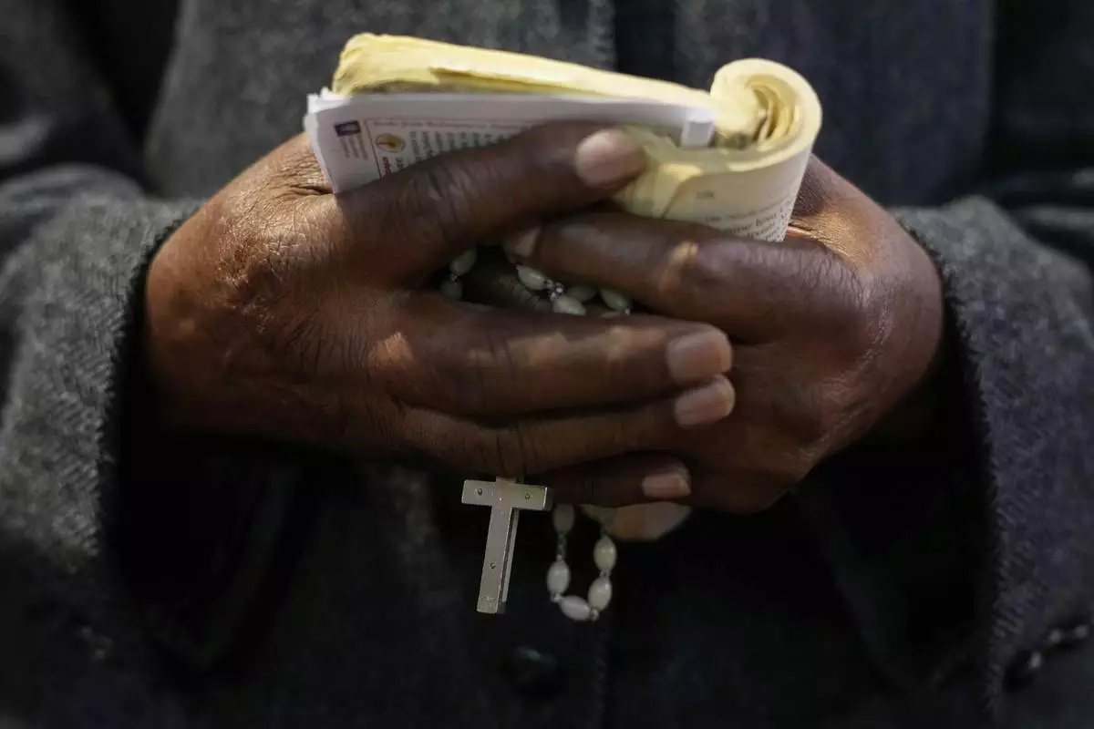 A Catholic holds a crucifix during Pope Francis Memorial Mass, at the Cathedral of Christ the King, Johannesburg, South Africa, Wednesday, April 23, 2025. (AP Photo/Themba Hadebe)